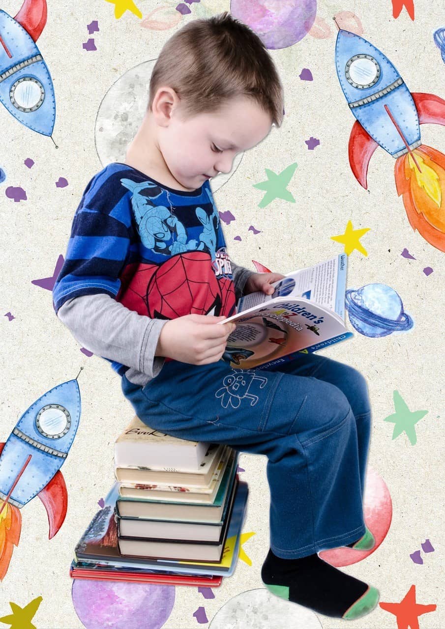Little boy sitting on top of books reading