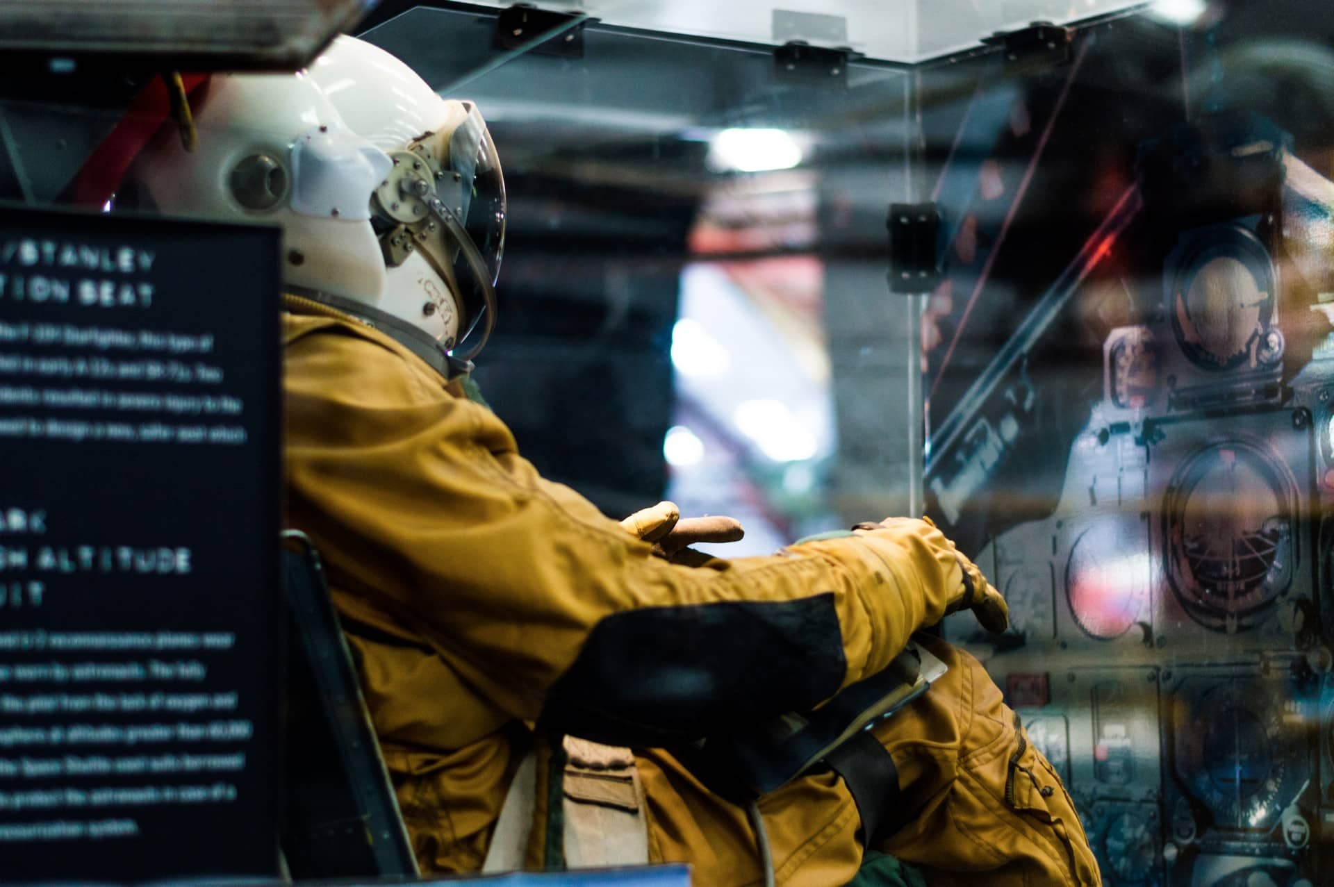 An astronaut from the back sitting in a spaceship